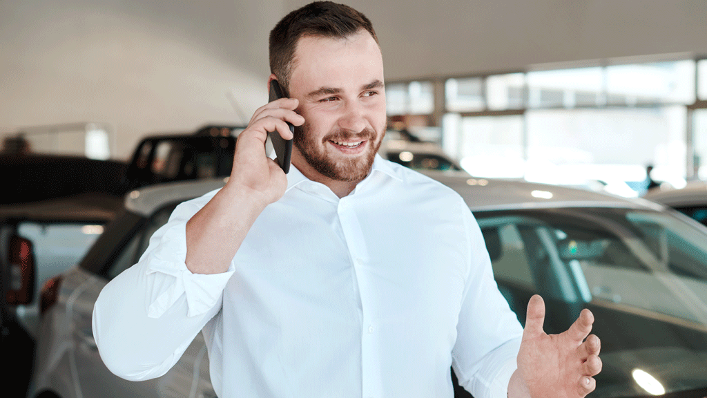 Homme négociant son contrat d'assurance auto par téléphone depuis son bureau