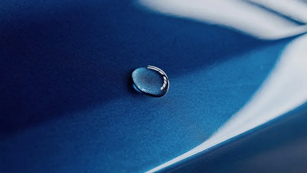 Vue rapprochée macro d'une carrosserie automobile neuve avec reflets lumineux illustrant la perte de valeur invisible d'un véhicule